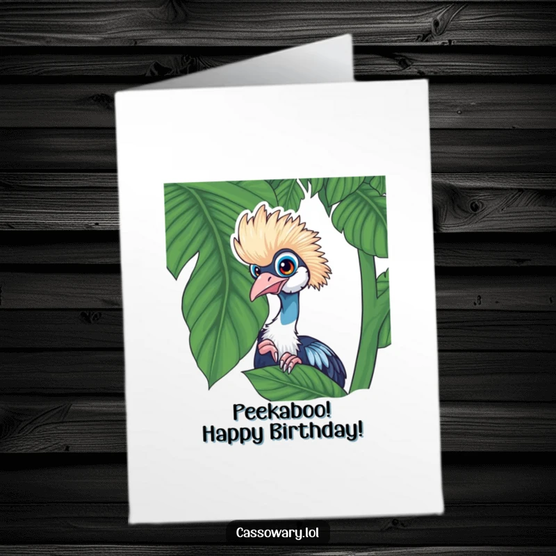 Funny Free Printable Birthday Card: A cassowary playfully peeking from behind a large, lush tropical leaf with wide eyes.