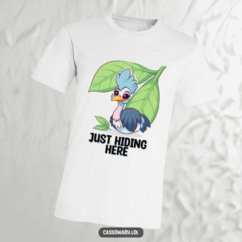 Funny cassowary t-shirt featuring a cheerful bird peeking playfully from behind a large leaf, radiating curiosity and charm.